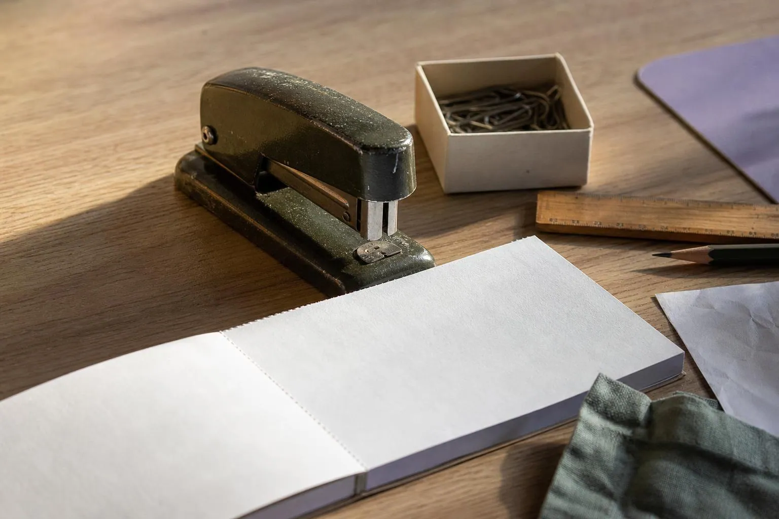 Gros plan d’un bureau de cabinet avec un carnet à souche, une agrafeuse ancienne, des trombones et une règle en bois